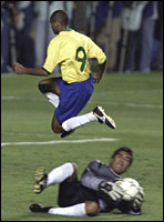 Brazilian striker Ewerthon jumps over Peruvian goalie Flavio Miranda. - REUTERS/Paulo Whitaker 