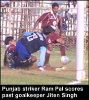 Punjab striker Ram Pal scores past goalkeeper Jiten Singh