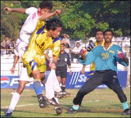 Goa Ratan Singh (yellow jersey) meets a cross before Railways 'keeper Sangram Mukherjee can reach the ball. 
