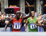 Paul Kosgei of Kenya (L) raises his arm as he runs ahead of Jaouad Gharib (R