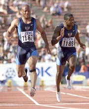 Maurice Greene (1167) of the U.S. seen crossing the finish line in pain next to compatriot Tim Montgomery (1188) to win the men's 100 meter final at the World Championships in Athletics, in Edmonton in this August 2001